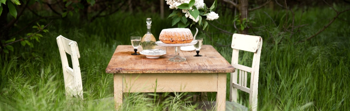 A beautifully set table with two chairs, placed in the middle of the Alentejo plains, surrounded by scenic countryside.