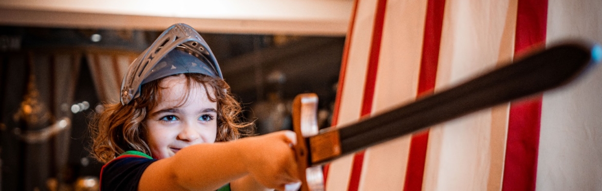 Young child dressed as a knight with toy sword