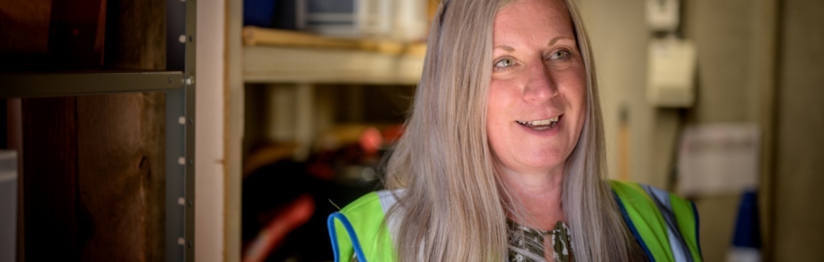 Woman wears a fluorescent jacket in a workshop.