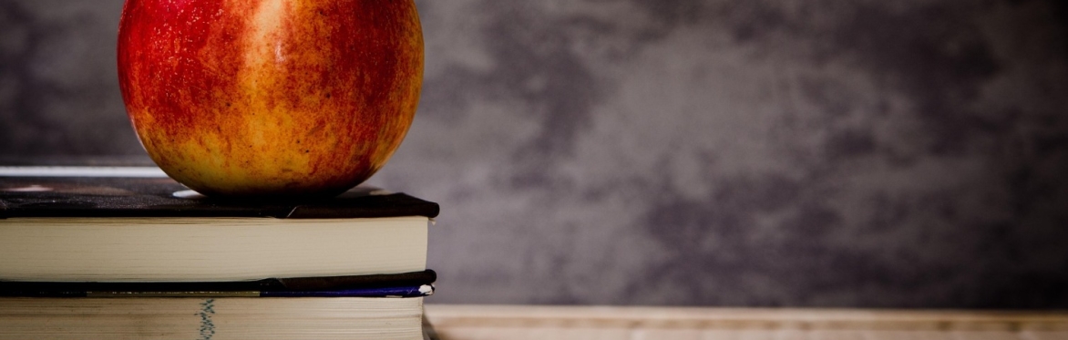 An apple rests on top of some books