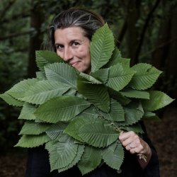 Sauna Master Katie Bracher holding a fan of leaves