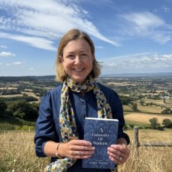 Author Chloe Turner holding up her book A Calamity of Waters in front of the Severn Vale where it is set