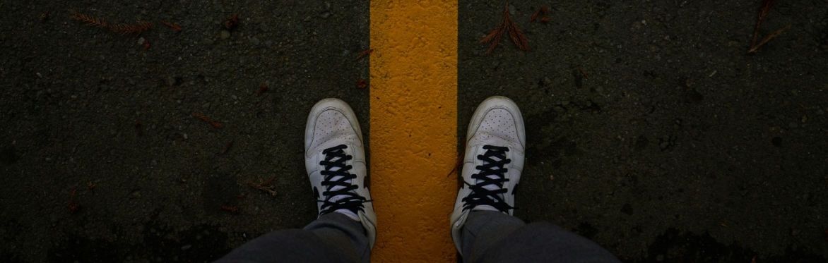 A person's feet standing on a yellow line, Photo by Karen Kasparov