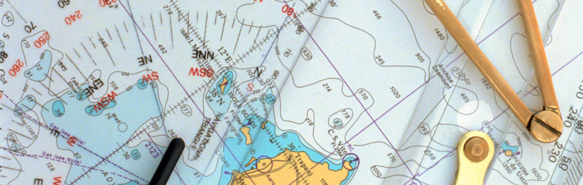 Nautical chart with contour lines and coastal details, overlaid with a pair of brass dividers and a ruler. The image conveys navigation and exploration.