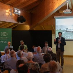 Gruppo di persone sedute, che ascolta una conferenza su Villa Daziaro