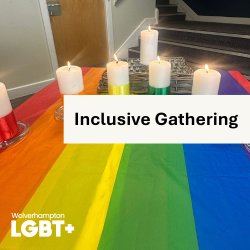a picture of lit candles on a table with a rainbow table cloth