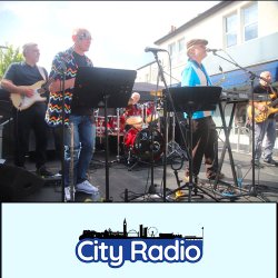 Band playing with log of City Radio