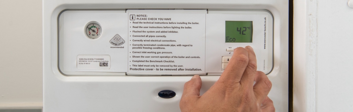 Someone is managing the temperature setting on a boiler