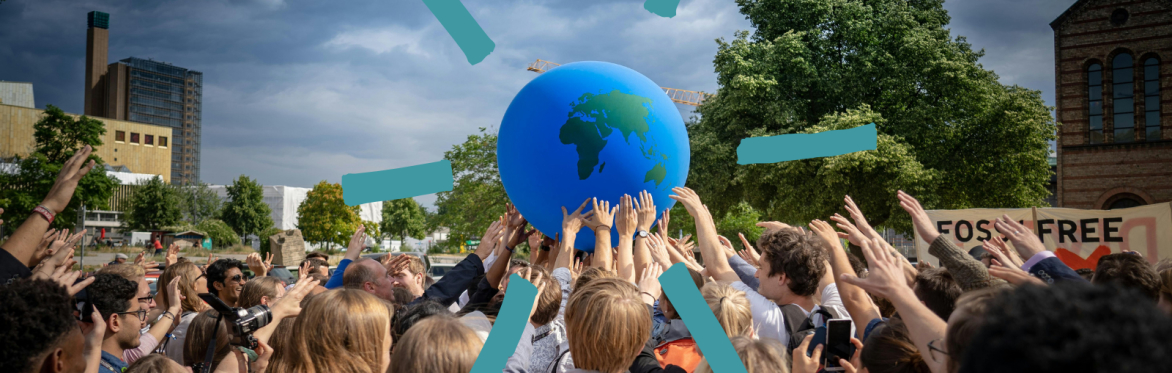 People gathered outside holding a globe