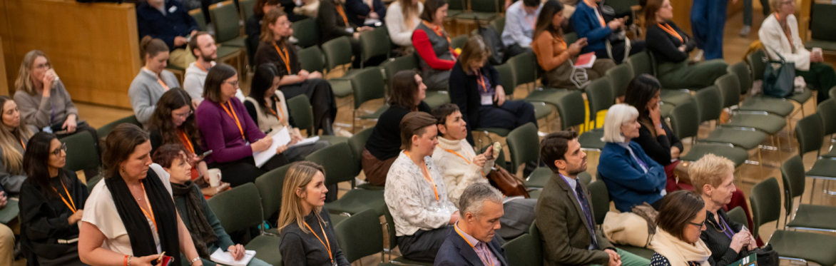 An audience sat in a lecture hall listening to a session