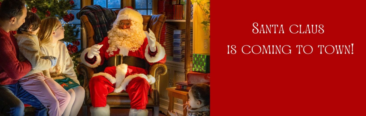 Father Christmas is sitting down and reading a list. He is surrounded by gifts