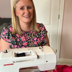 Mell sitting next to her sewing machine