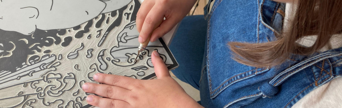 The artist Rebeca Ventura carves a linoleum block.