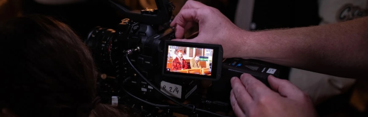 A close up of someone's hands adjusting settings on a video camera.