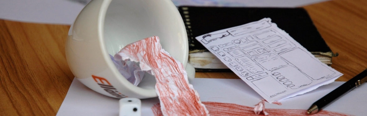 Coffee flows out of an upturned cup. A die sits beside it.