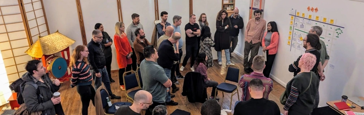 Group of people at an open space event, gathered around the agenda board