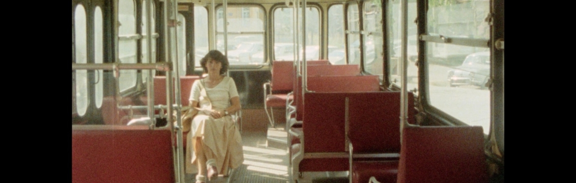 A person sat on a bus facing the camera.