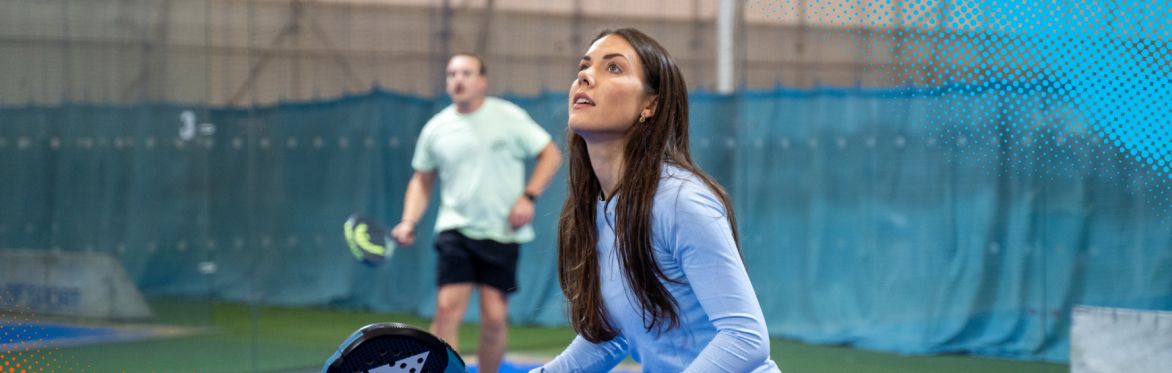 Women holding a padel racket, waiting for a ball