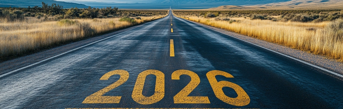 an empty road going into the horizon with the number '2026' written on it in yellow paint.