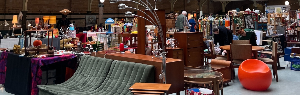 Tiled Swimming Pool Floor, People Looking around at stalls. Furniture, Rugs, Art is displayed