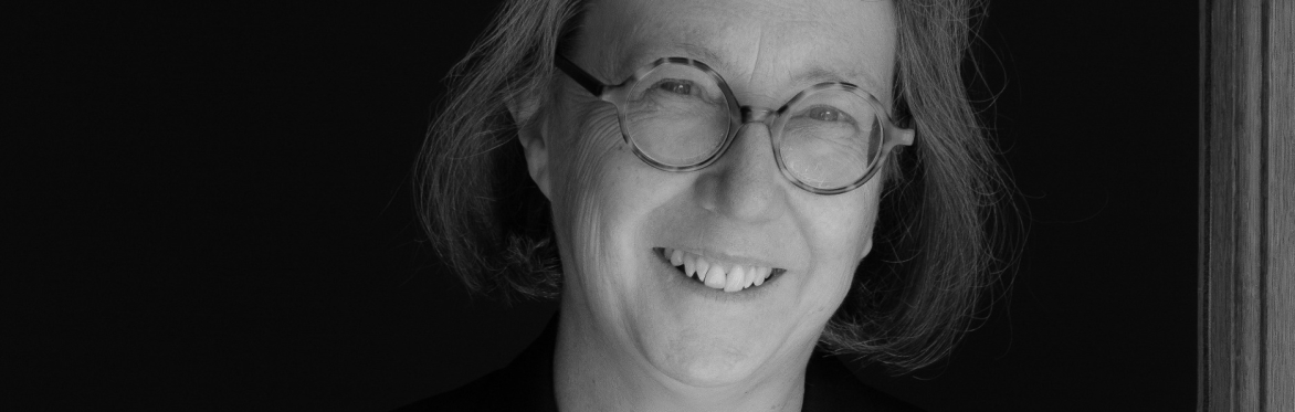 Photograph of Jane Shaw: Robert Taylor. Jane is a middle aged lady with a friendly smile. She faces the camera in a black and white photograph. She has chin-length hair and round glasses on.