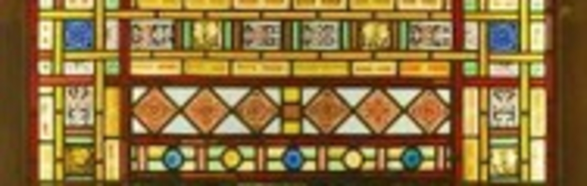 a stained glass window featuring horses in centre of design