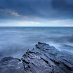 A stormy cloud over a stormy big body of water