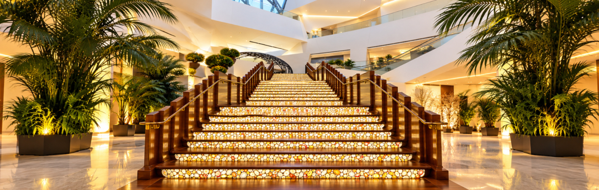 Interior of The Shops at Crystals featuring sculptural architecture, luxury storefronts, and colorful flower displays.
