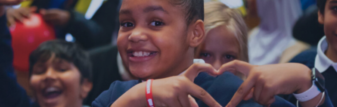 A happy girl making a heart with her hand