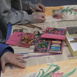 Two art students using oil pastels to draw a still life image