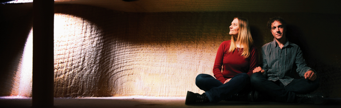 Vicki Swan + Jonny Dyer are sitting inside a the nykelharpa