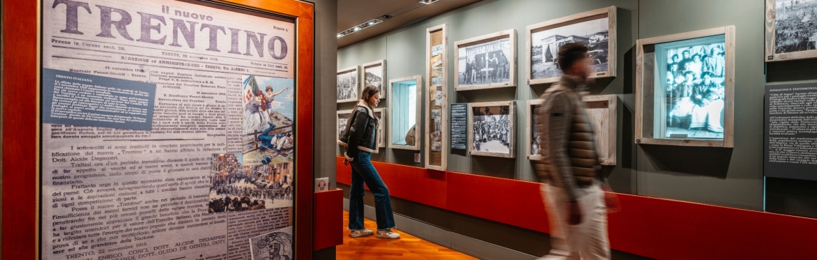 Secondo piano del Museo Casa De Gasperi, in cui ci sono due ragazzi che guardano le fotografie scattate nelle 'Città di legno" della Prima Guerra Mondiale