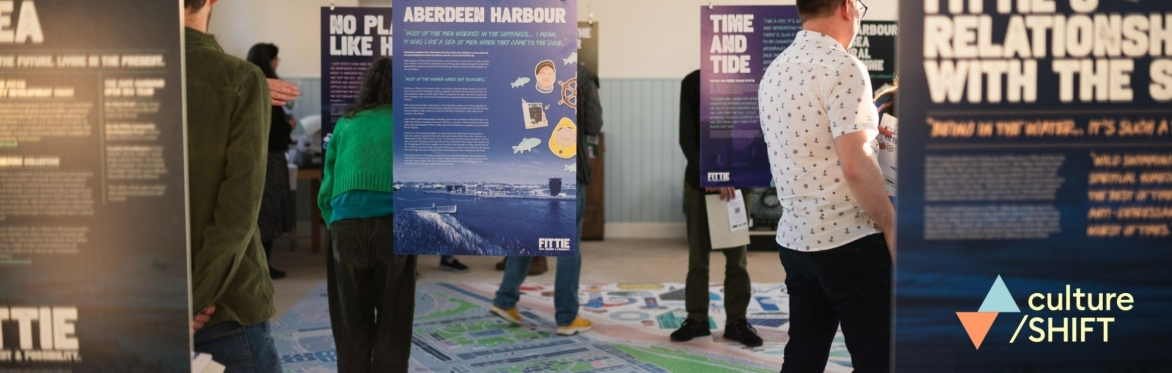 People looking at posters hanging in room