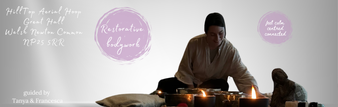 A woman lights a candle in a calm space surrounded by sound bowls and cushions.