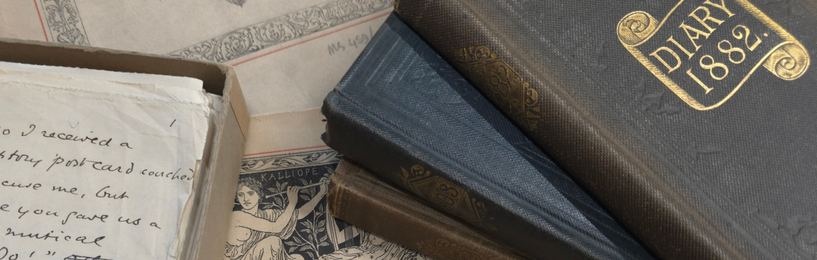 Various papers, notes and books about music with a pile of bound volumes, all laid out on a table. The top volume has "Diary 1882" written in gold.