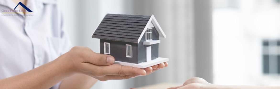 A person holds out a model home
