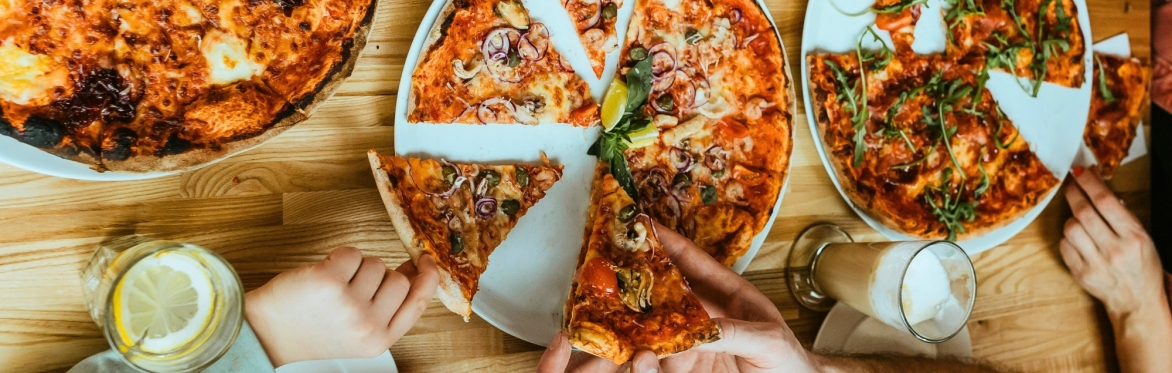 A load of hands grabbing pizza