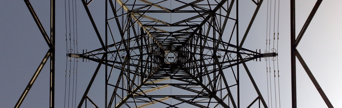 View of electricity pylon from the centre of the structure looking up to the apex. With symmetrical beams and cross members