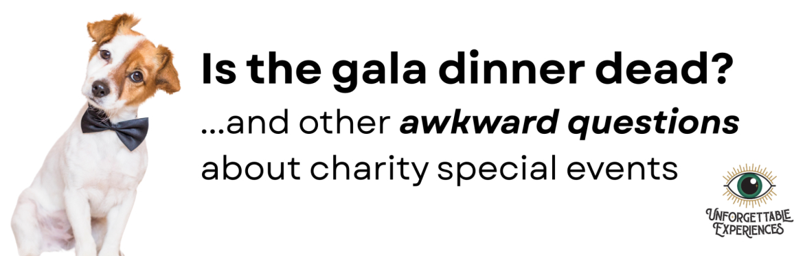 Small white and brown dog wearing a black tie looking inquisitive