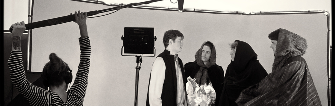 People in historic dress on a film set.