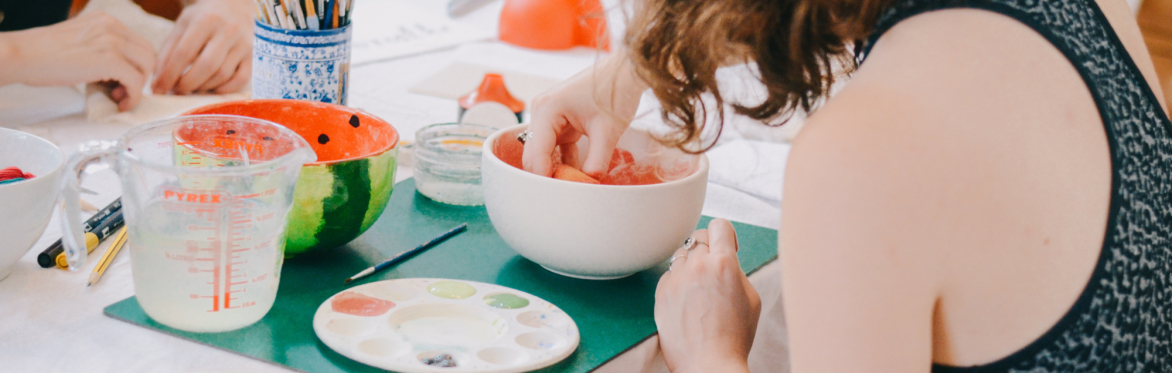 Image of guest pottery painting a bowl in a creative class