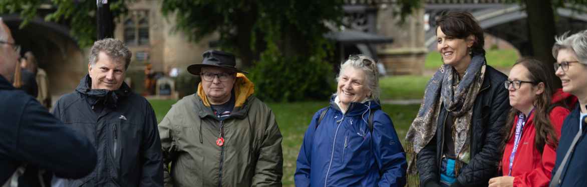 Participants gathered on a riverside path listening to a guide during a York rivers trail walk exploring local rivers, heritage and resilience.