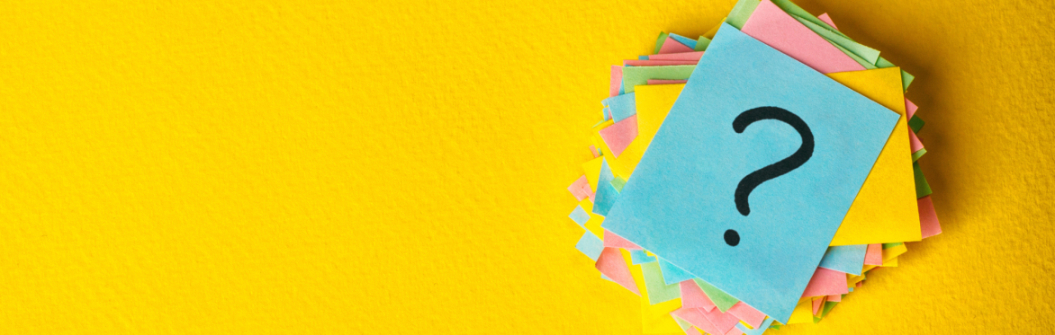 A bunch of different coloured post-its with a queston mark on the top one