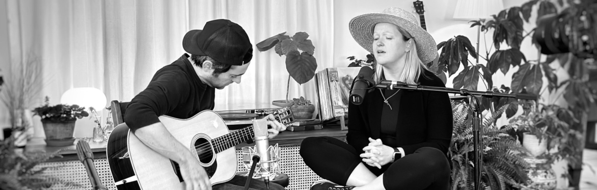 Carmen Keigans and Brian Whitman of Heavy Weighs the King, playing acoustically in their front room
