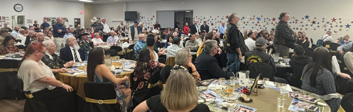 Veterans in the audience stand as their branch's song is performed