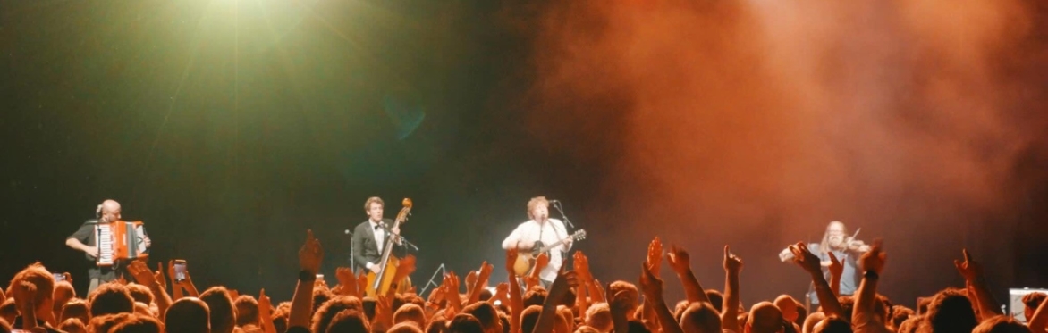 Hyde Family Jam on stage in front of a crowd with their hands in the air