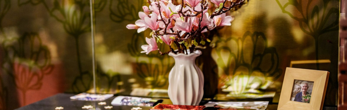 Flowers in a vase with photographs of loved ones