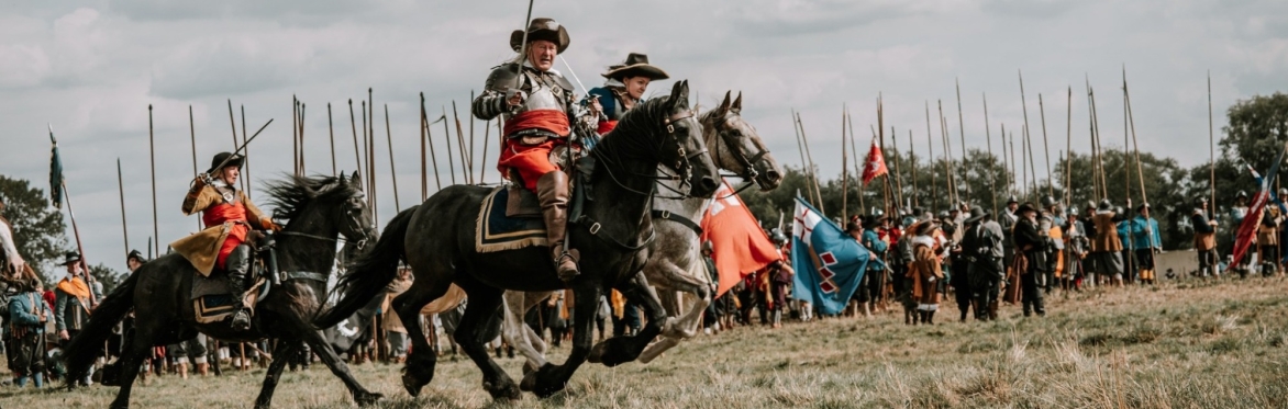 Cavalry troops gallop across an English Civil War battlefield