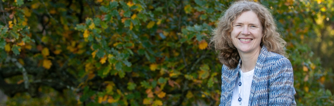 A photo of the trainer, Kesta Fleming, with a background of leaves