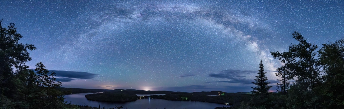 The Milky Way panoramic image over a small lake.